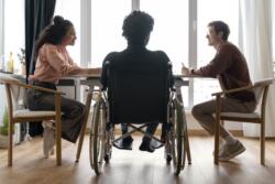 Personne en fauteuil roulant autour d'une table avec des amis